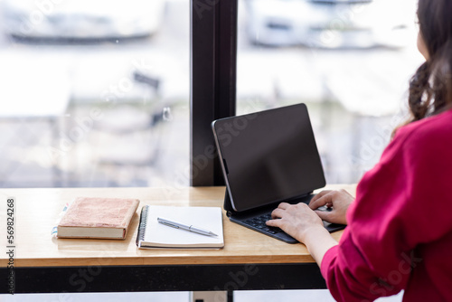 Happy Young Indian Asian Business woman sitting on Digital Tablet work desk Workplace. 