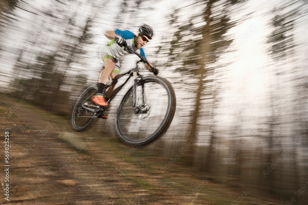 Mountain biker performing stunt in forest Mountain biker performing stunt in forest