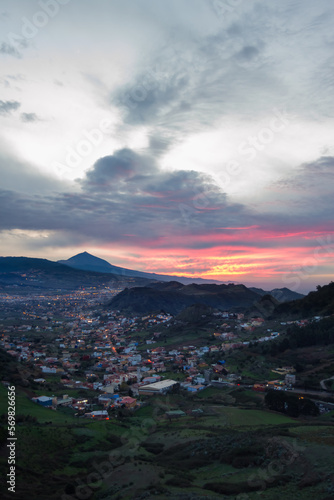 beautiful sunset, view of the city of La Laguna, you want the viewpoint of Jardina, with the silhouette of the Teide volcano against the light. City at night. City lights. Pink clouds. Nightfall. Tene