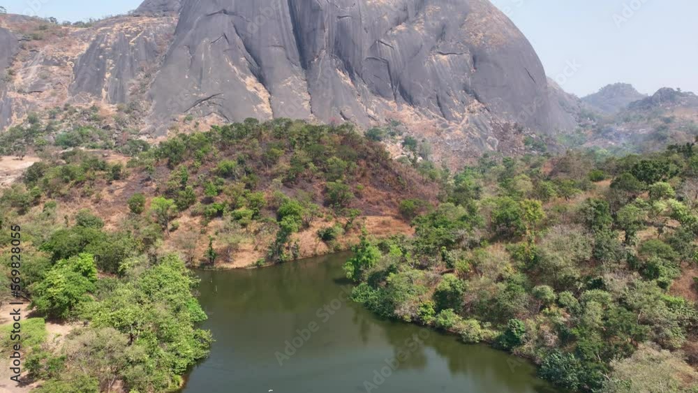 Aerial - Rising reveal wide shot of an inselberg rock Aerial - Rising reveal wide shot of an inselberg rock