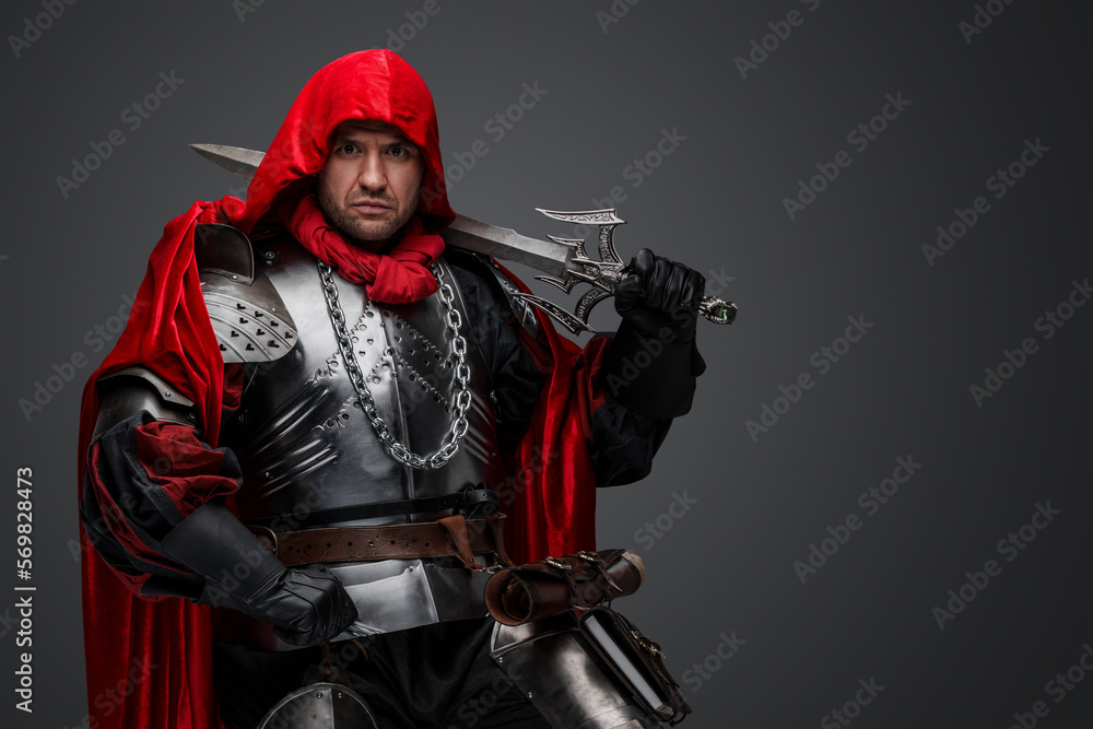 Shot of dark knight dressed in steel armor and red robe against gray background. Shot of dark knight dressed in steel armor and red robe against gray background.
