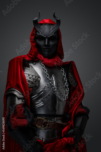 Portrait of dark member of mysterious cult dressed in red robe and black mask.