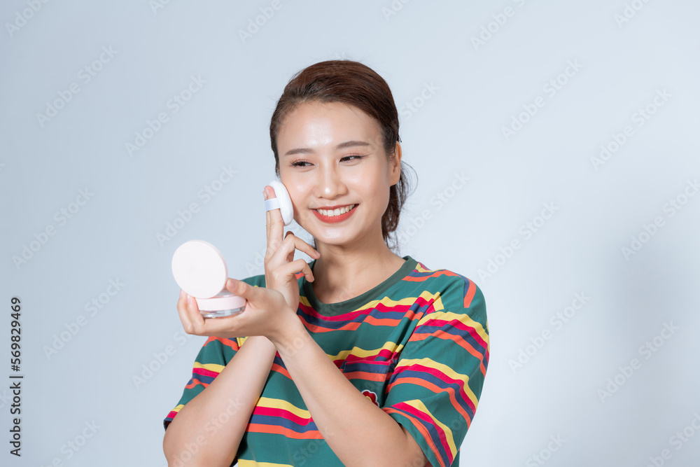 beautiful young woman using beauty blender for applying foundation for make-up on face isolated beautiful young woman using beauty blender for applying foundation for make-up on face isolated