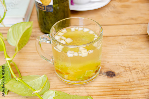 Té caliente con frutas picadas adentro en taza transparente 