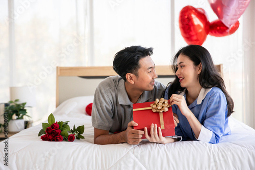 Beautiful young couple surprise with rose and gift in bedroom,Valentine's Day  concept.