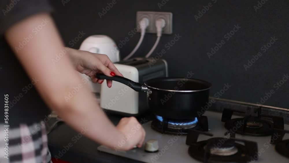 Woman turns on gas on stove, woman is going to cook Woman turns on gas on stove, woman is going to cook