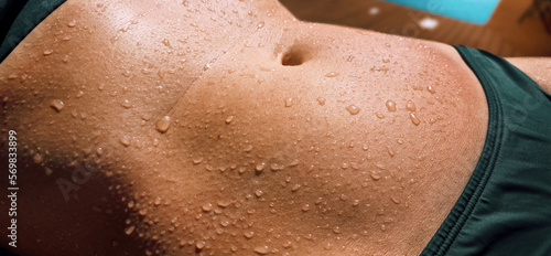 wet woman s body in bikini. water drops on stomach