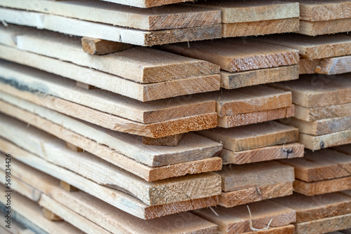 Wooden planks at lumber warehouse. Piles of wooden boards at store outdoors. Wood timber stack of wooden planks construction material.