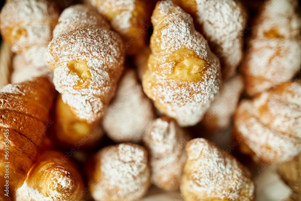 sweet croissants sprinkled with powdered sugar, top view. baked croissants sprinkled with powdered sugar on a wooden board. Close up croissants sprinkled with powdered sugar. sweet croissants sprinkled with powdered sugar, top view. baked croissants sprinkled with powdered sugar on a wooden board. Close up croissants sprinkled with powdered sugar.