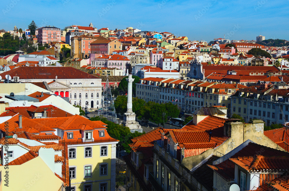 Aerial landscape of city center of Lisbon. View from top of Santa Justa Lift. Vintage buildings with red tile roofs. Rossio Square with D. Pedro IV Statue. Travel and tourism concept