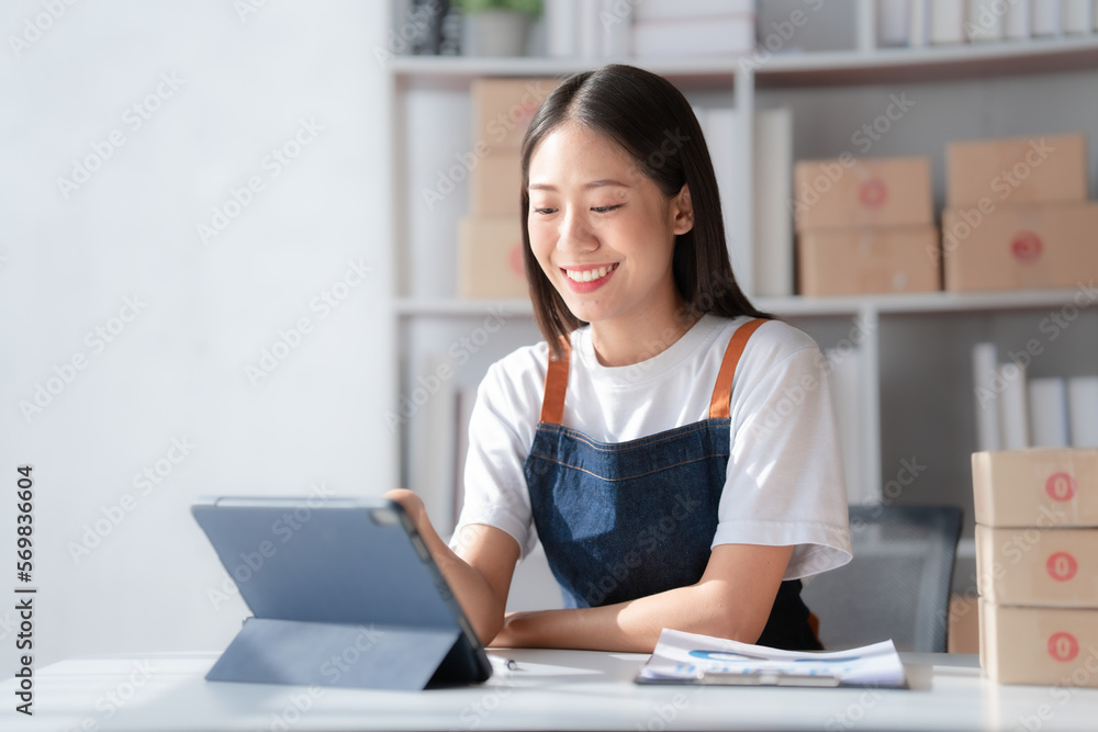 Attractive young mixed race chinese half thai ethnicity SME owners woman entrepreneurs working on receipt box and check online orders, SME home business ideas online. Attractive young mixed race chinese half thai ethnicity SME owners woman entrepreneurs working on receipt box and check online orders, SME home business ideas online.
