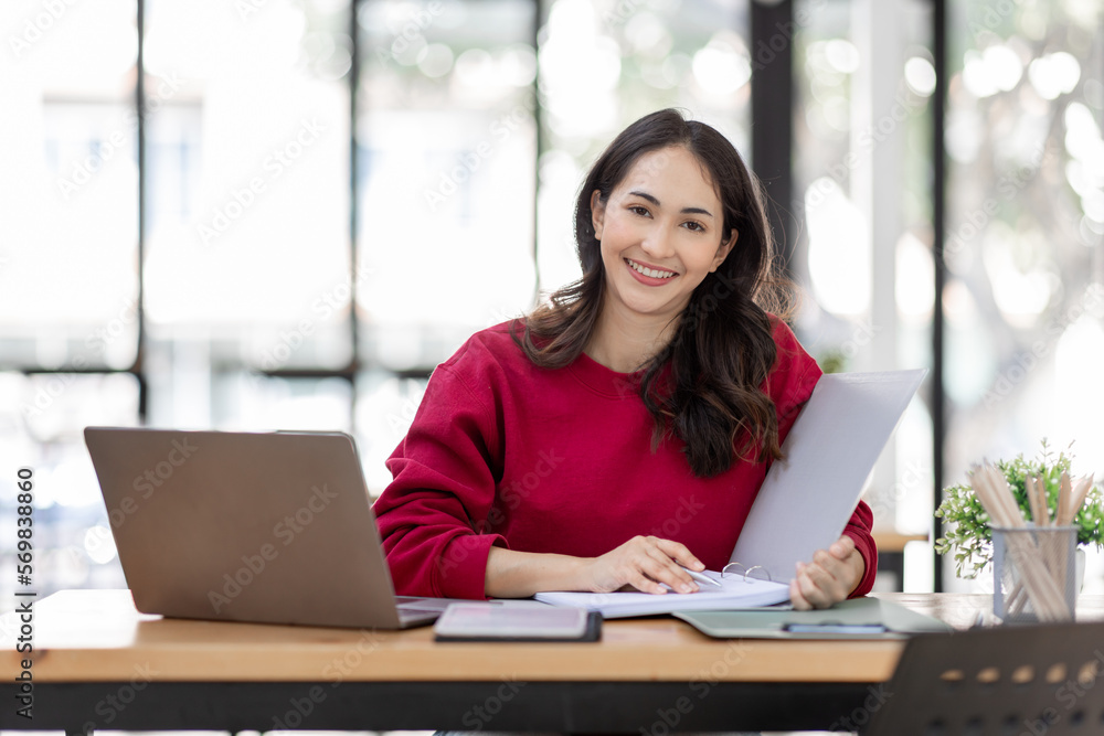Shot of a asian young business Female working on laptop computer in her workstation.Portrait of Business people employee freelance online marketing e-commerce telemarketing concept. Shot of a asian young business Female working on laptop computer in her workstation.Portrait of Business people employee freelance online marketing e-commerce telemarketing concept.