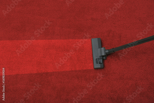Vacuuming dirty red carpet. Clean area after using device, top view