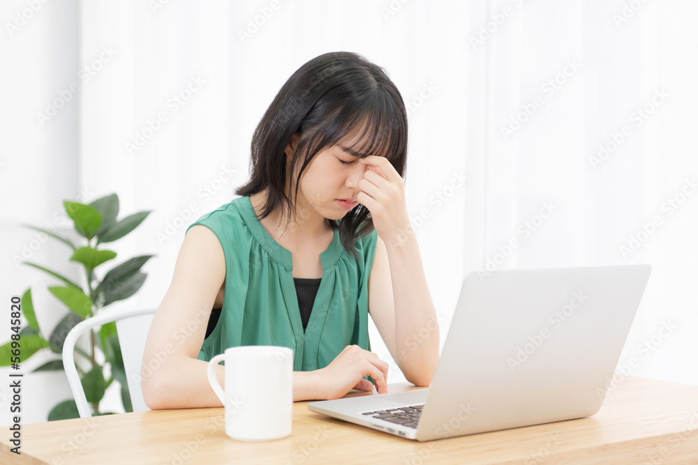 PC作業で目が疲れた若い女性