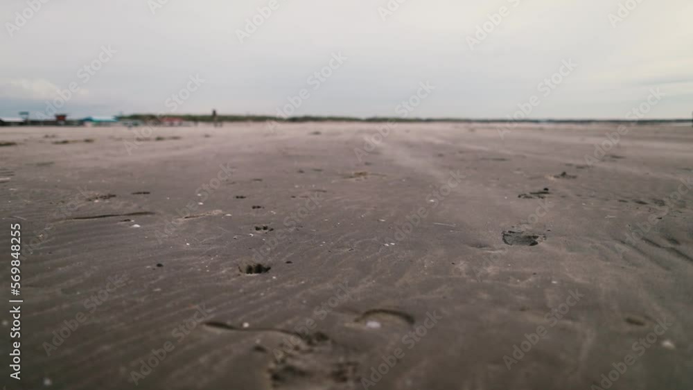 Sand sweeping up during bright windy day on wet beach. High quality FullHD footage Sand sweeping up during bright windy day on wet beach. High quality FullHD footage