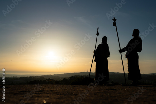 Silhouette of pilgrims at sunset on the road to Santiago - Saint James road in Monte del Gozo, Galicia - Spain