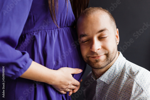 man is happy with the white belly of his pregnant wife