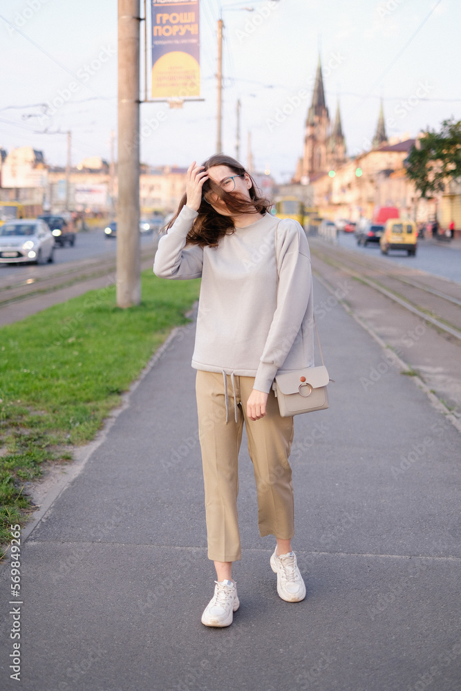 Portrait of a young woman in glasses walking through the evening city Portrait of a young woman in glasses walking through the evening city