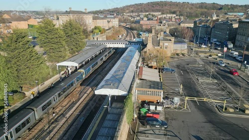 Train parked in train station with passengers  leaving the train with platform and carpark UK. photo