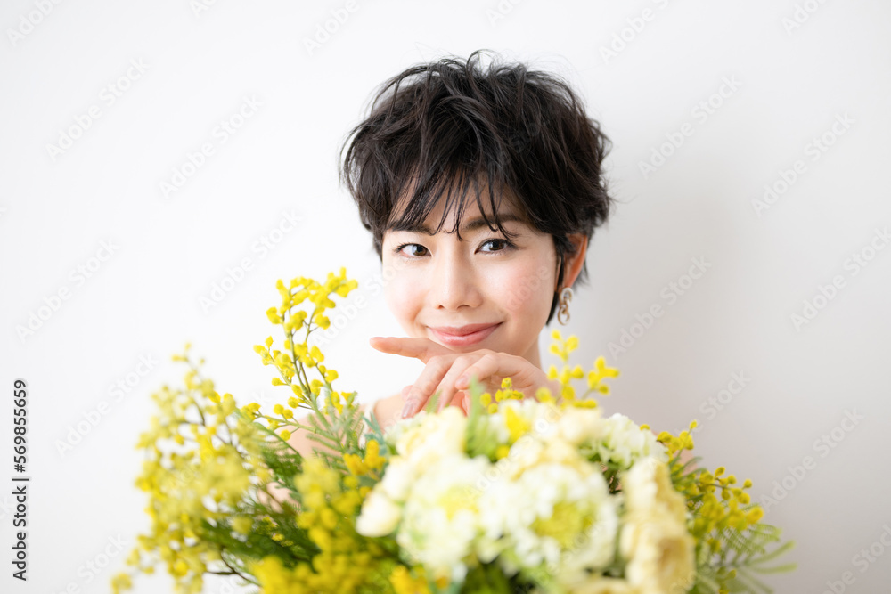 Pretty Asian woman holding a bouquet of mimosa flowers Pretty Asian woman holding a bouquet of mimosa flowers