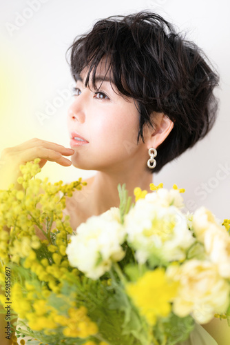 ウェディングや前撮り美容イメージに使えそうなミモザの花束を抱える可愛らしい女性 アップ 横顔