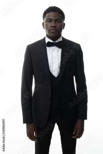 Cool young positive african american man in classic elegant black suit on white background. Portrait of showman or presenter of festive event who smiles at camera.