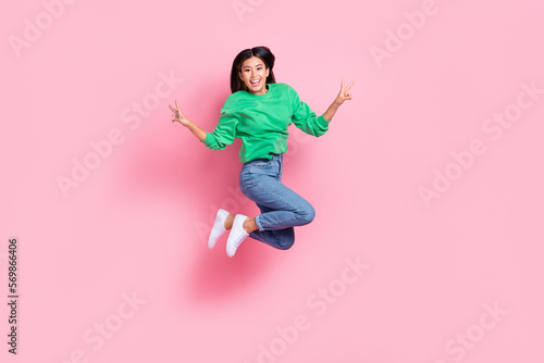 Fototapeta Naklejka Na Ścianę i Meble -  Full body photo of energetic active filipino lady jumping demonstrate v-sign isolated on pink color background