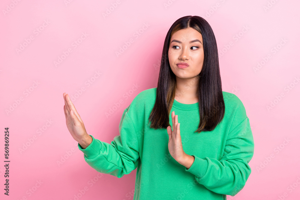 Photo of serious spoiled girl dressed green sweatshirt showing arms no empty space isolated pink color background Photo of serious spoiled girl dressed green sweatshirt showing arms no empty space isolated pink color background
