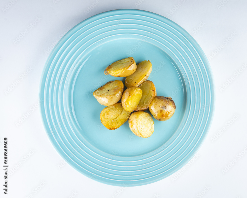 Fototapeta premium Light blue plate with potato. Baby potato top view. Side dish with potato.