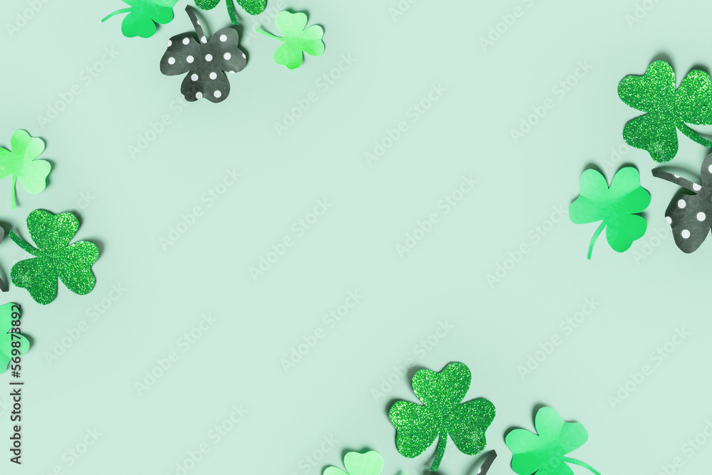 St. Patrick's Day balnk greeting card. Paper clover leaves on colored background with copy space