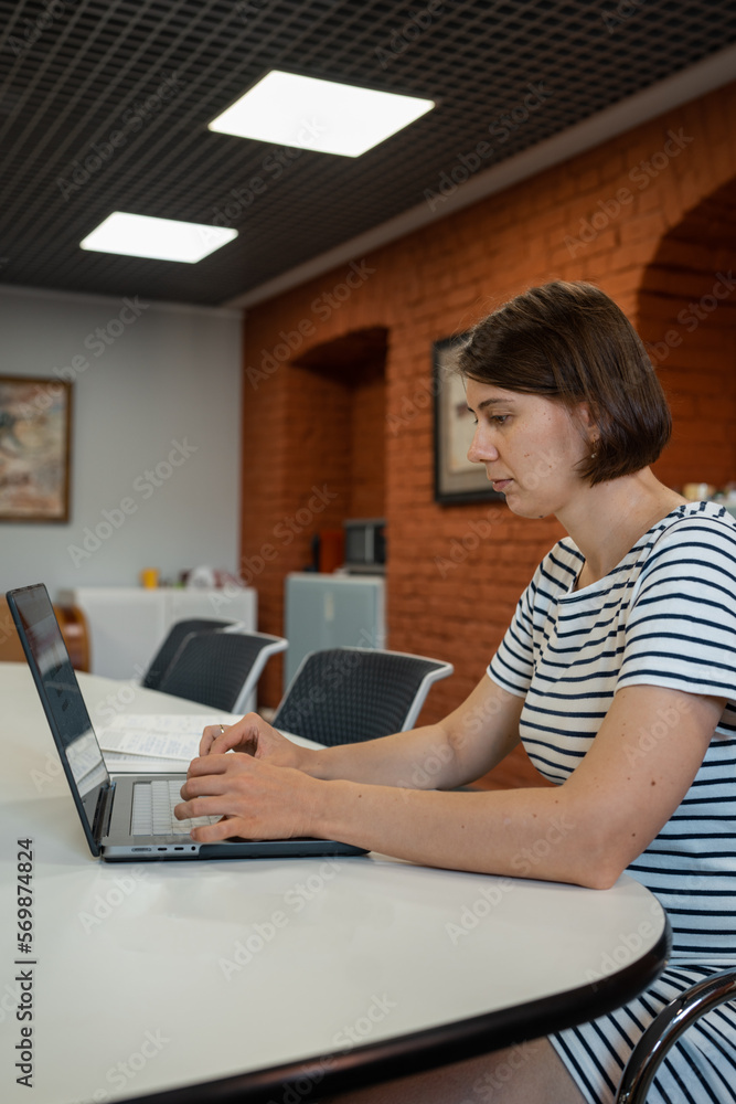 Pregnant woman sitting at desk with computer in office. Real person in real situation. Pregnant woman sitting at desk with computer in office. Real person in real situation.