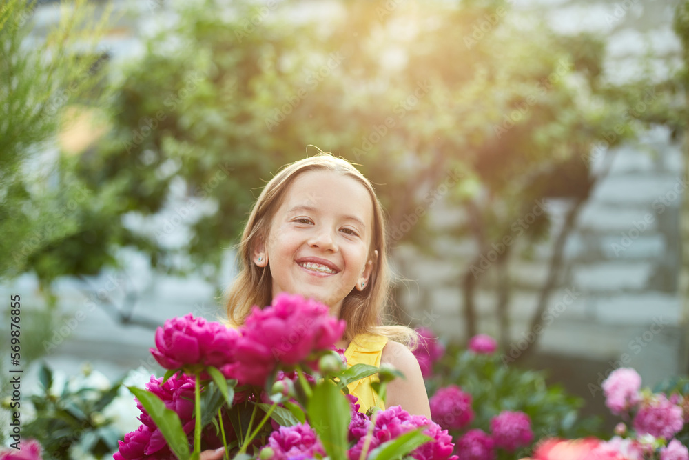 Happy little girl with braces in the garden in bushes of peonies Happy little girl with braces in the garden in bushes of peonies