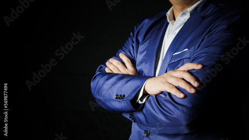 Close up confident businessman in blue elegant business suit with arms crossed in front of body Isolated on black background