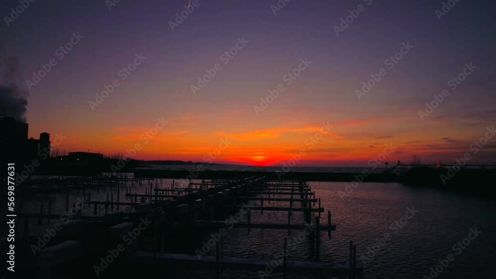 Drone flying at low altitude over empty boat dock with beautiful sunset on the horizon. Sky for copy space. Aerial backward Drone flying at low altitude over empty boat dock with beautiful sunset on the horizon. Sky for copy space. Aerial backward