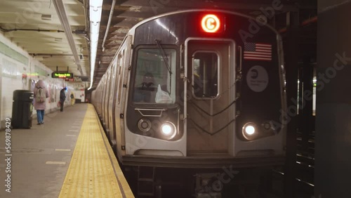 Train Arrives in NYC Subway Station, doors open, woman boards the train.  People practicing Social Distancing due to Covid-19 Pandemic Lockdown.  Brooklyn, New York City. 60 FPS. photo