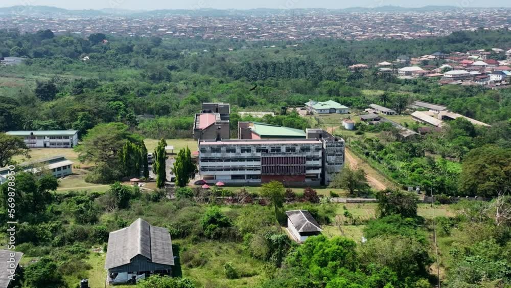 Aerial - Forward tilting wide shot of a building on a university campus surrounded by trees Aerial - Forward tilting wide shot of a building on a university campus surrounded by trees