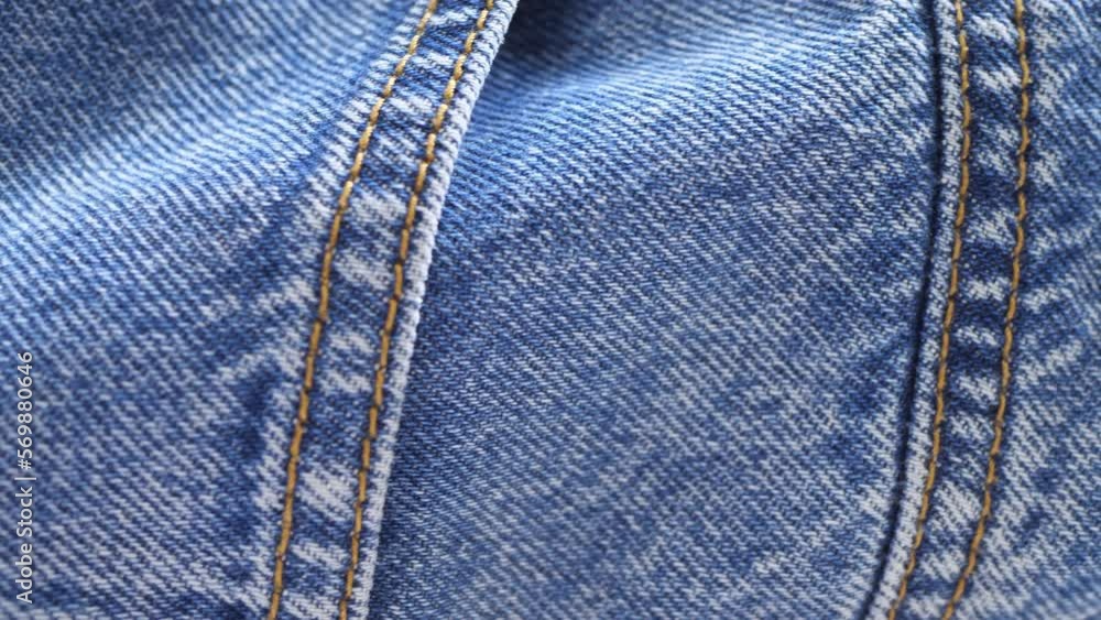 Movement of the camera over the texture of the blue denim fabric. A close-up of the denim. Movement of the camera over the texture of the blue denim fabric. A close-up of the denim.