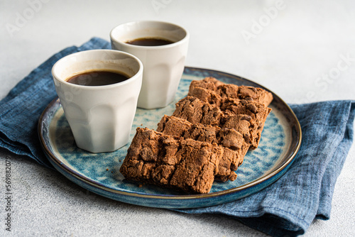 Two cups of coffee and a plate of chocolate cookies