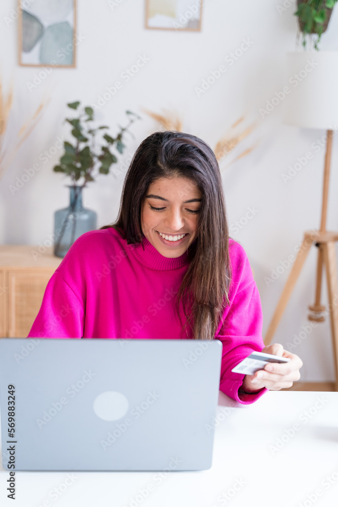 Smiling woman using smartphone in home office shopping online