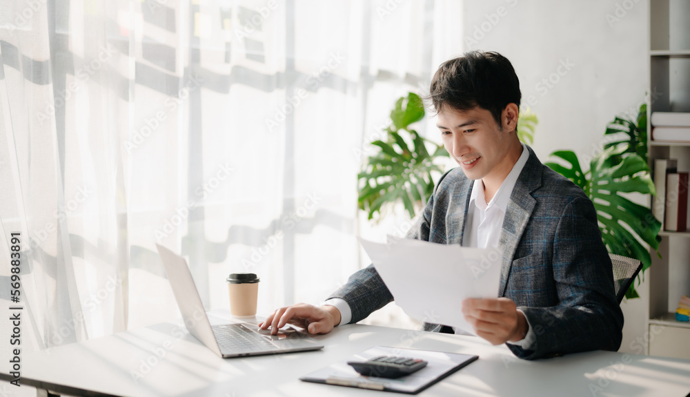Young business man working at office with laptop, tablet and taking notes on the paper.. Young business man working at office with laptop, tablet and taking notes on the paper..