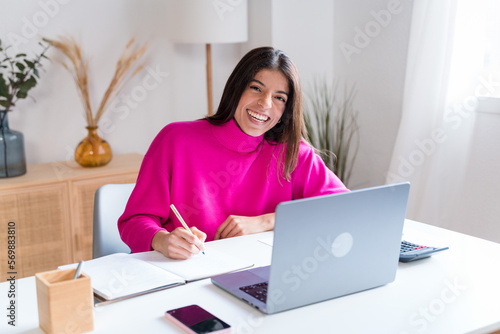 Smiling woman writing in notepad © The Attico Studio