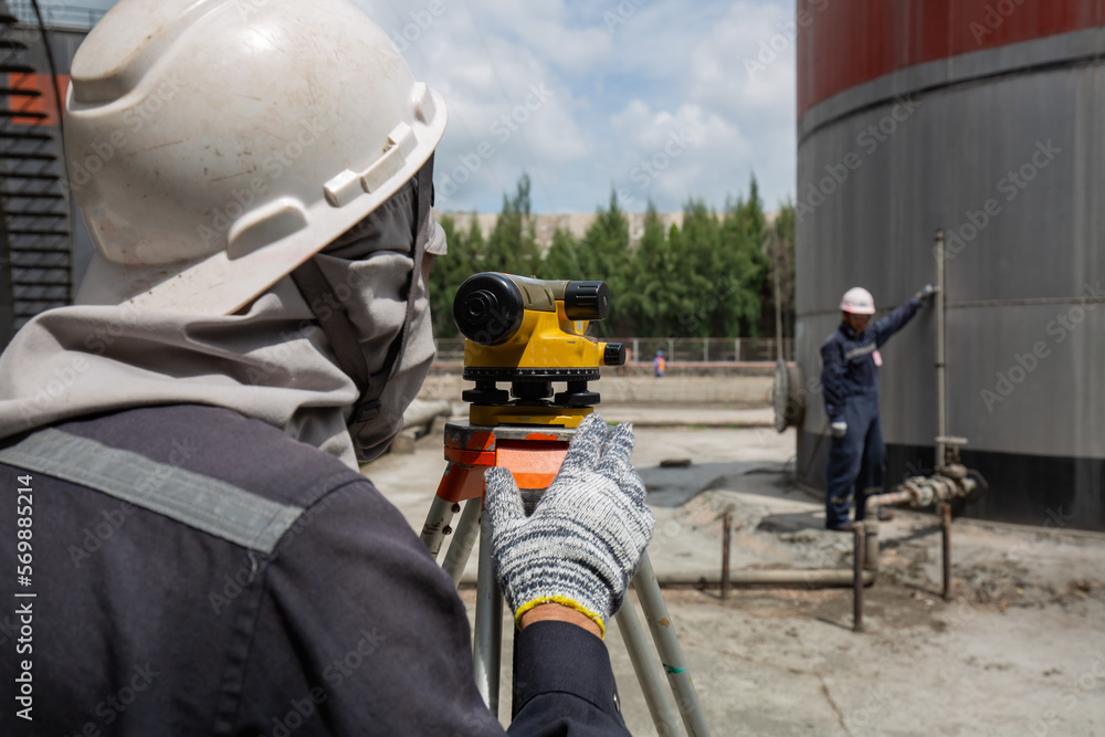 Male worker inspection survey level tank Male worker inspection survey level tank