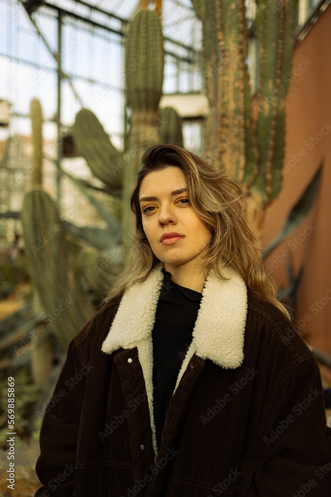 Fototapeta premium Young beautiful woman in front of cactus.