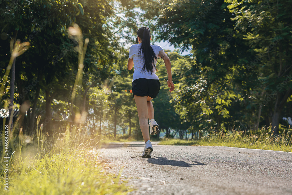 Silhouette of young woman running sprinting on road. Fit runner fitness runner during outdoor workout. Silhouette of young woman running sprinting on road. Fit runner fitness runner during outdoor workout.