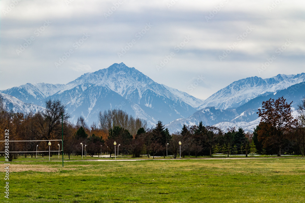 Fototapeta premium Park in autumn and mountains in the background. Almaty