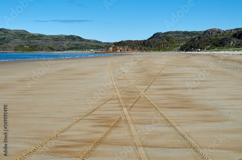 Crossroads of tire tracks on the sand of the sea coast