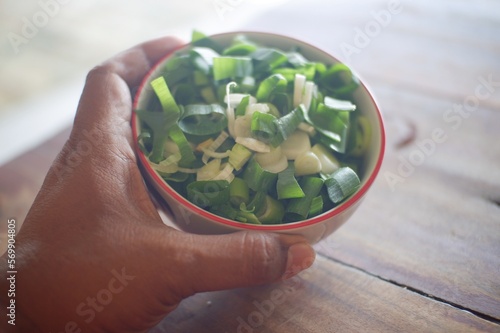 hands holding a bowl of fresh herbs