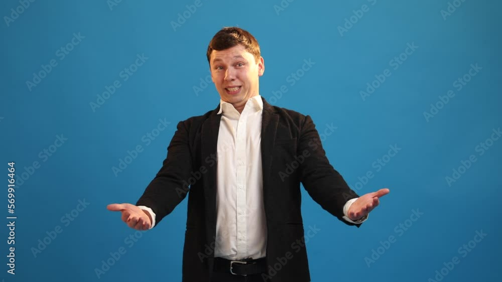 Smiling businessman waving hand asks come here, inviting to get good job tempting invite over blue studio background. Friendly man standing looking camera making invitation gesture and welcome sign Smiling businessman waving hand asks come here, inviting to get good job tempting invite over blue studio background. Friendly man standing looking camera making invitation gesture and welcome sign