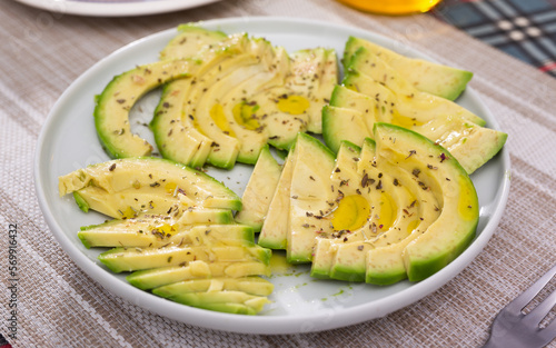 ripe avocado pulp cut into pieces sprinkled with lemon juice on a plate