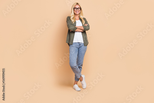 Full length photo of positive lovely lady wear stylish clothes promoting new collection empty space isolated on beige color background